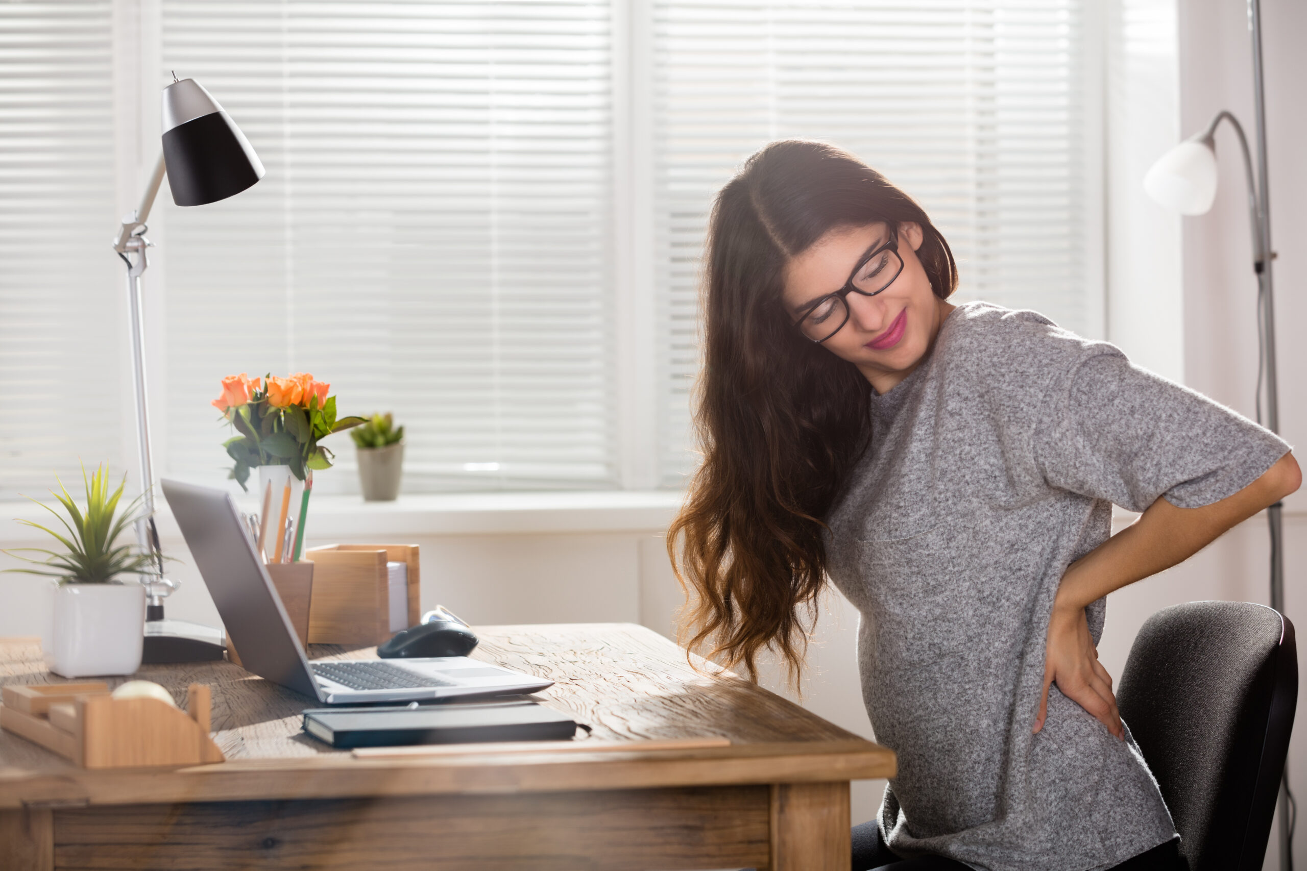 Young Attractive Businesswoman Having Back Pain In Office